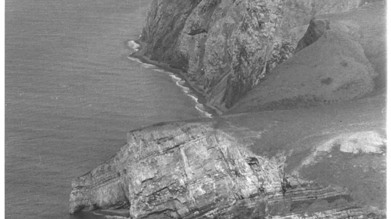 Black and white aerial view of the steep rocky coastline of cape lisburne