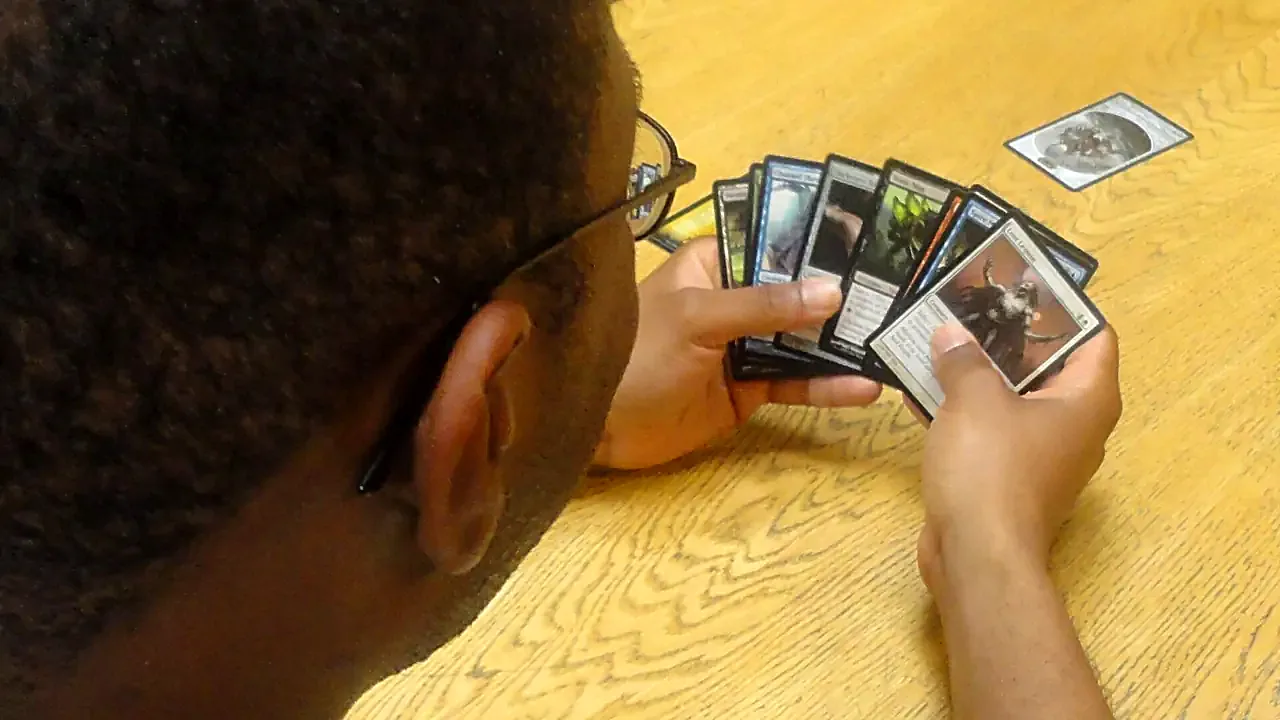Bruce Spraggins, a logistics planner with Multinational Battle Group East, evaluates his Magic- The Gathering cards befo