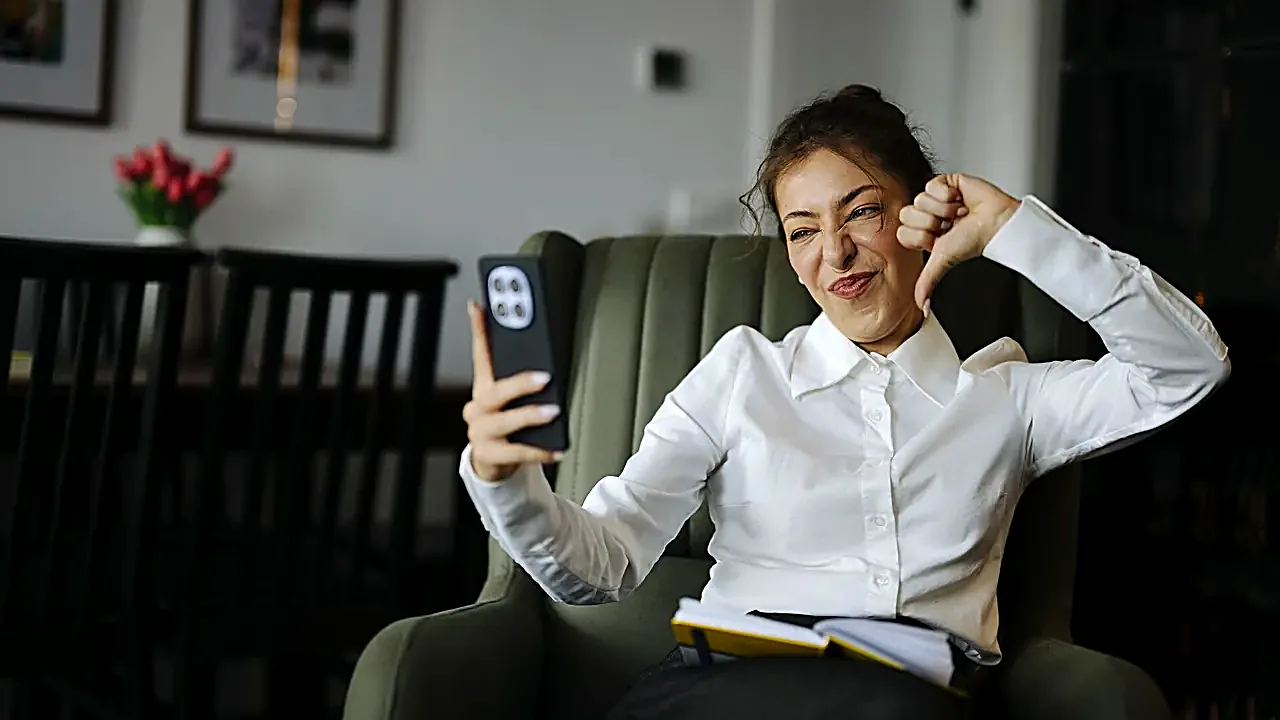 Woman sitting in a chair making a silly face while taking a selfie