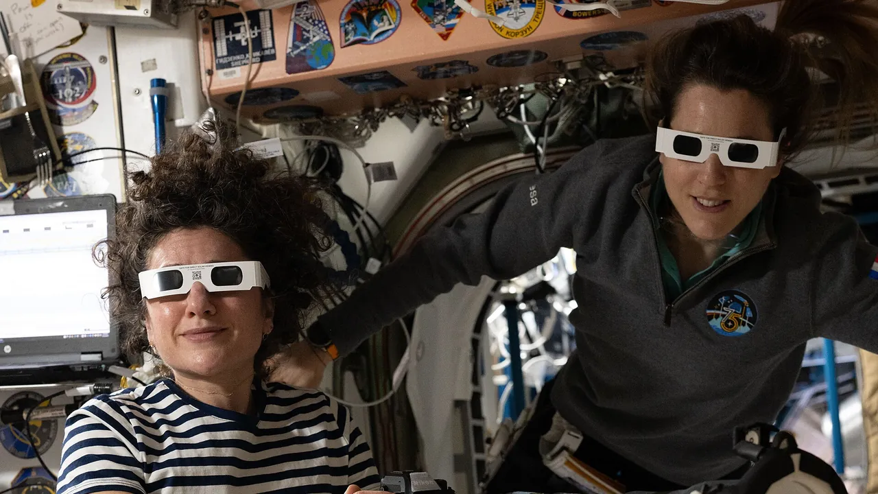 Expedition 75 crewmates Jessica Meir and Sophie Adenot wear solar eclipse glasses to protect their eyes